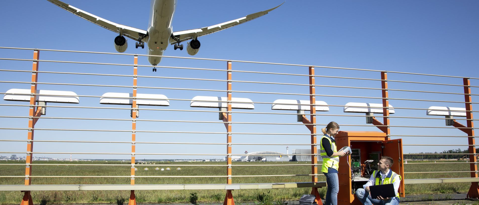 Zwei Flugsicherungsingenieure vor einem geöffneten Schaltkasten des Instrumentenlandesystems an einer Startbahn des Flughafens Frankfurt/M.